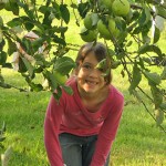 My older daughter peeking through the apple tree